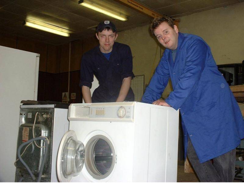 Volunteers working on a washing machine in the workshop